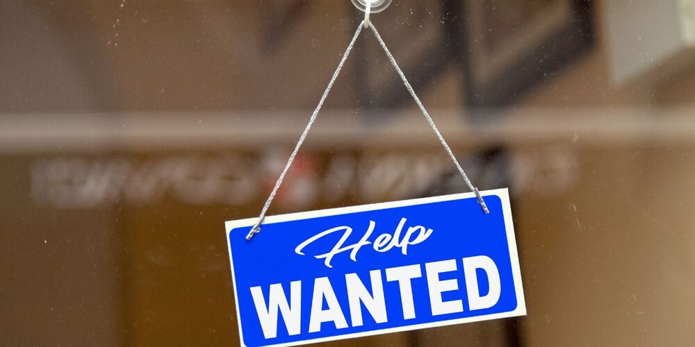 help wanted sign hanging in window