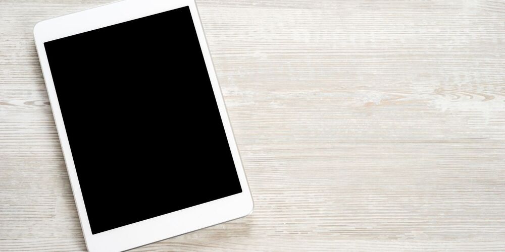 White tablet on a wooden table