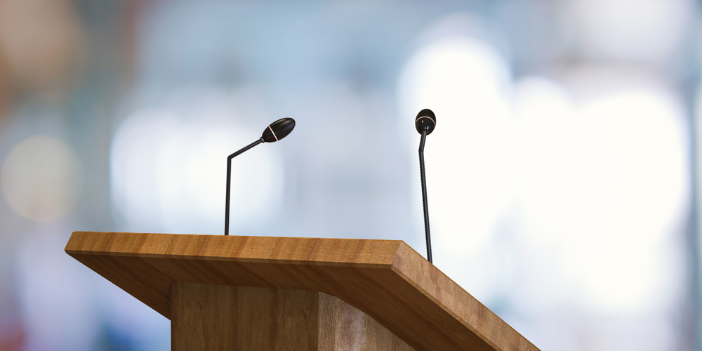 Image of two microphones on a podium