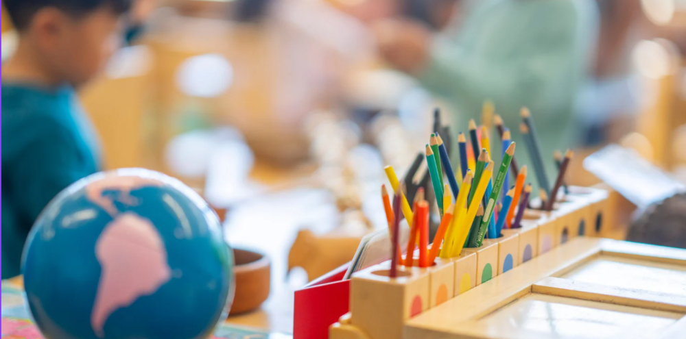 Classroom view with student, globe, and colored pencils