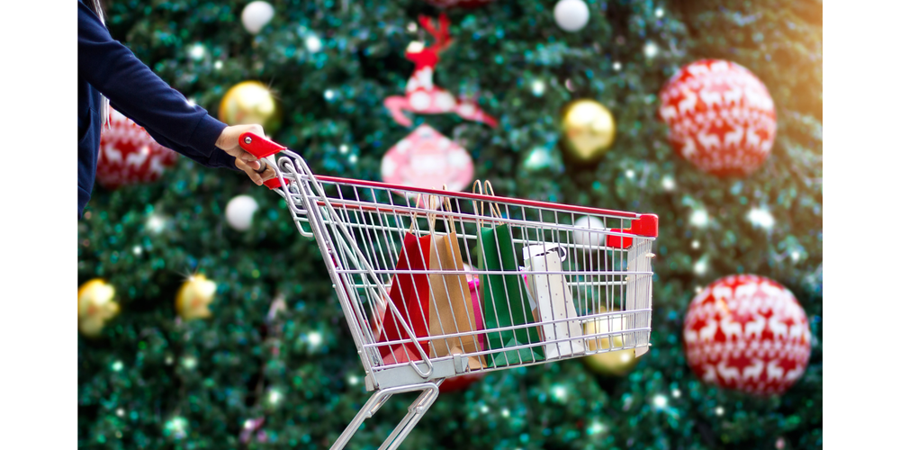ornaments on a tree with gift bags in a shopping cart