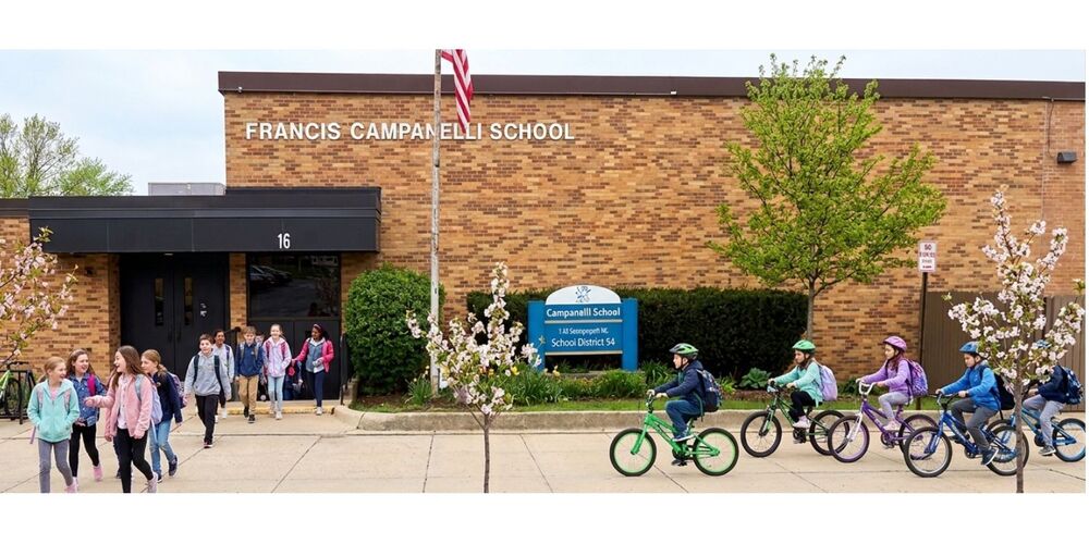 Image of students riding bikes and walking in front of Campanelli
