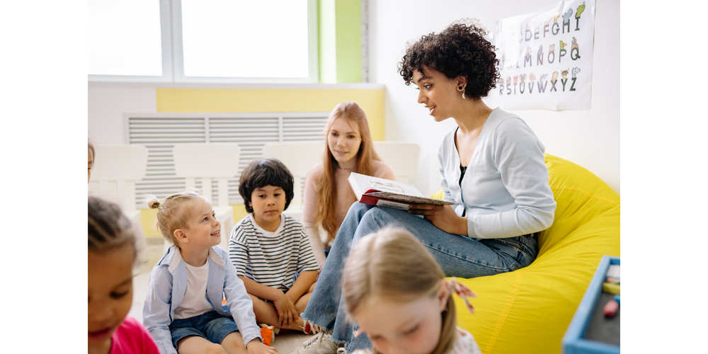 students listening to a teacher read a book
