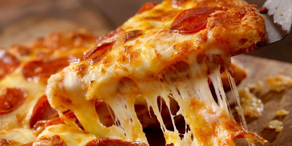 Slice of pizza being lifted with spatula
