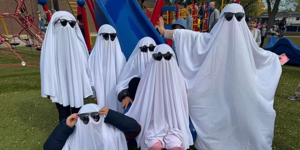 Students dressed up as ghosts with sunglasses on playground