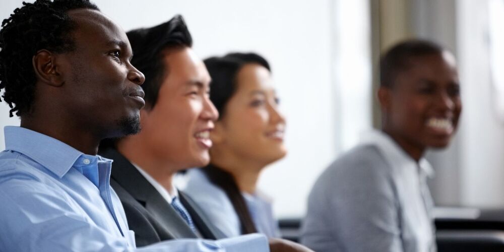 4 adults sitting at a meeting