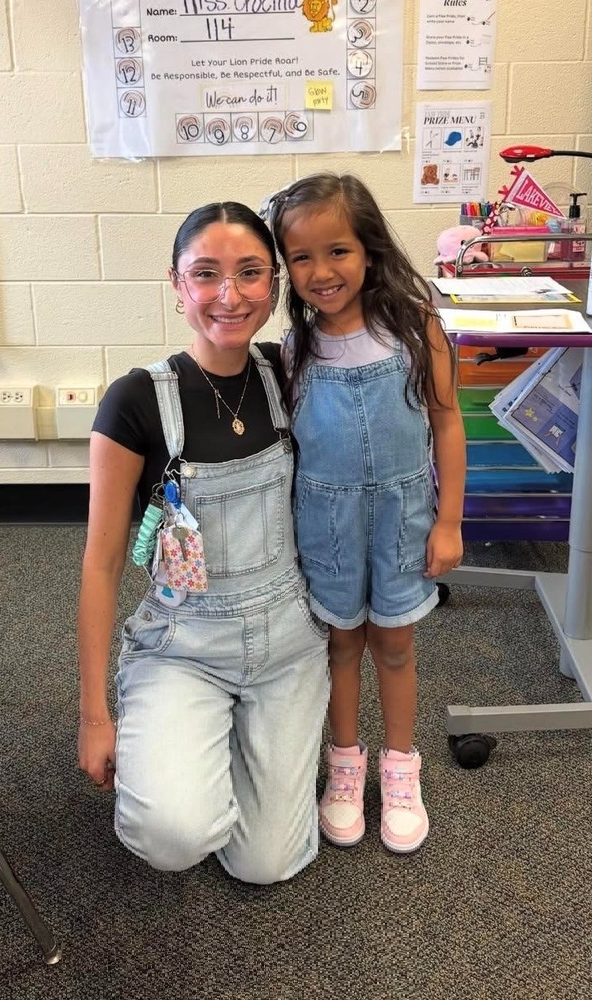 Girl standing next to her teacher