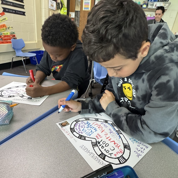 two students writing on a compliment may