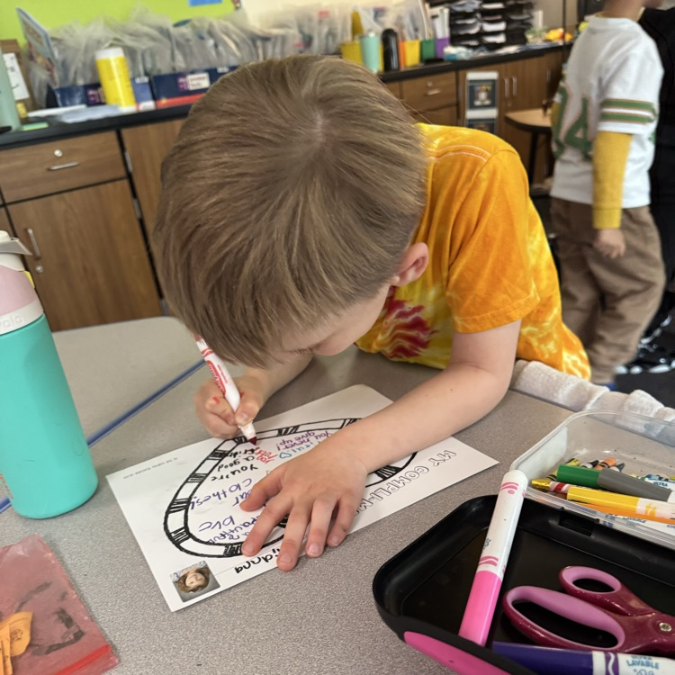 a student  writing on a complement mat