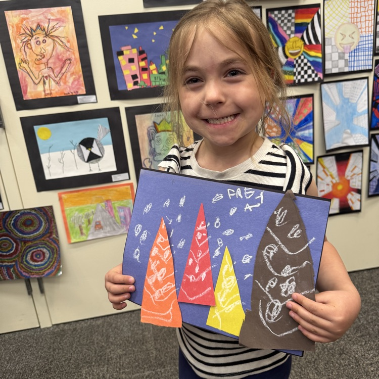student holding her artwork