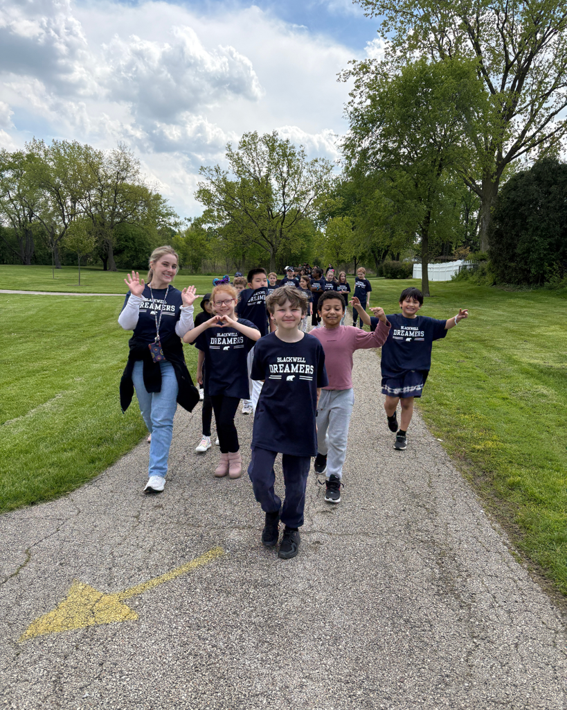 Teacher and students smiling and walking on a path
