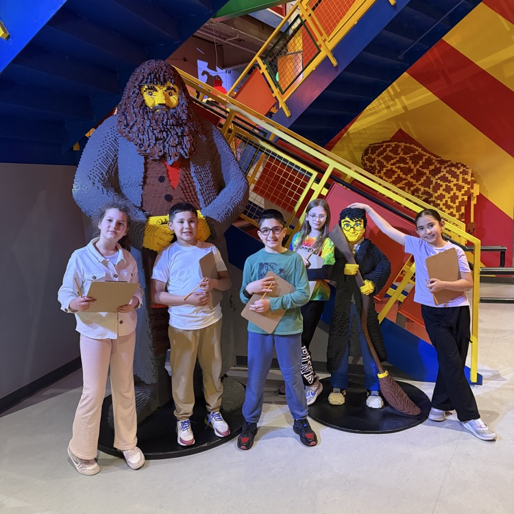 Fourth graders posing in front of a LEGO display
