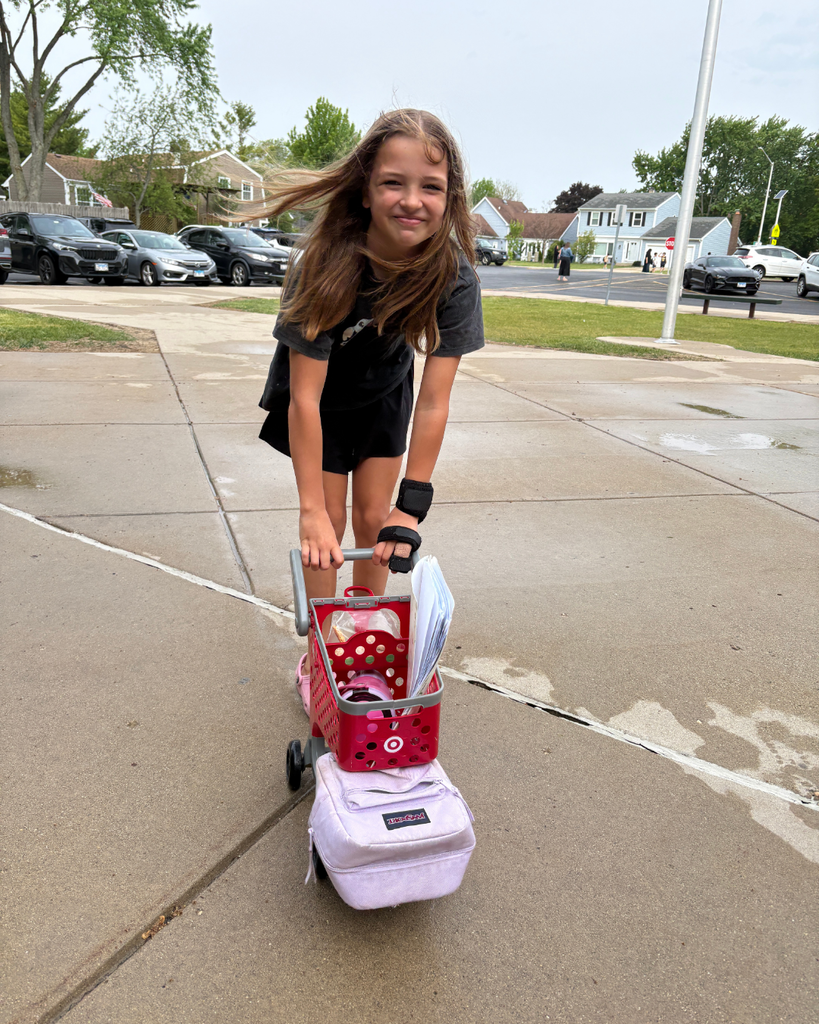 Student using a toy Target shopping cart as a backpack into school