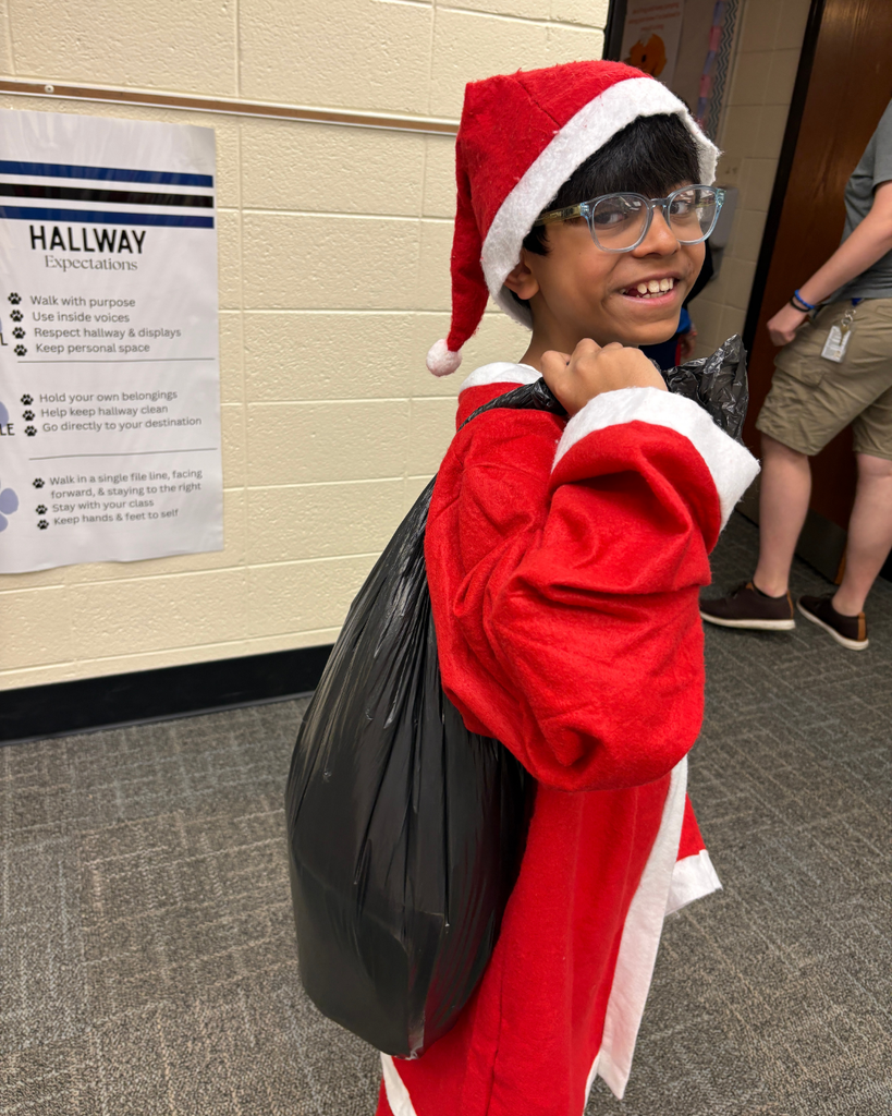 Student dressed as Santa Claus carrying a black trash bag into school as a backpack