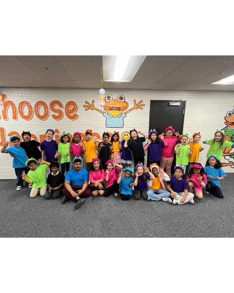 Students dressed in monster head bands and matching t-shirts making silly monster faces. 