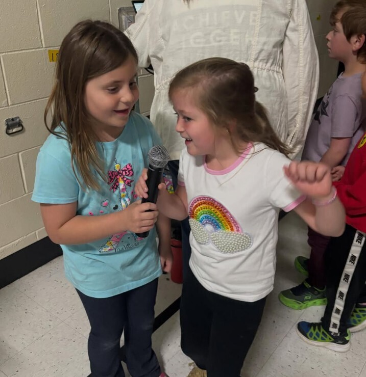 Two girls singning with microphone
