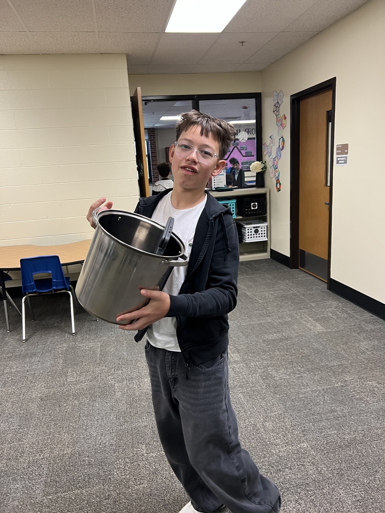 a student with a cooking pot as a backpack