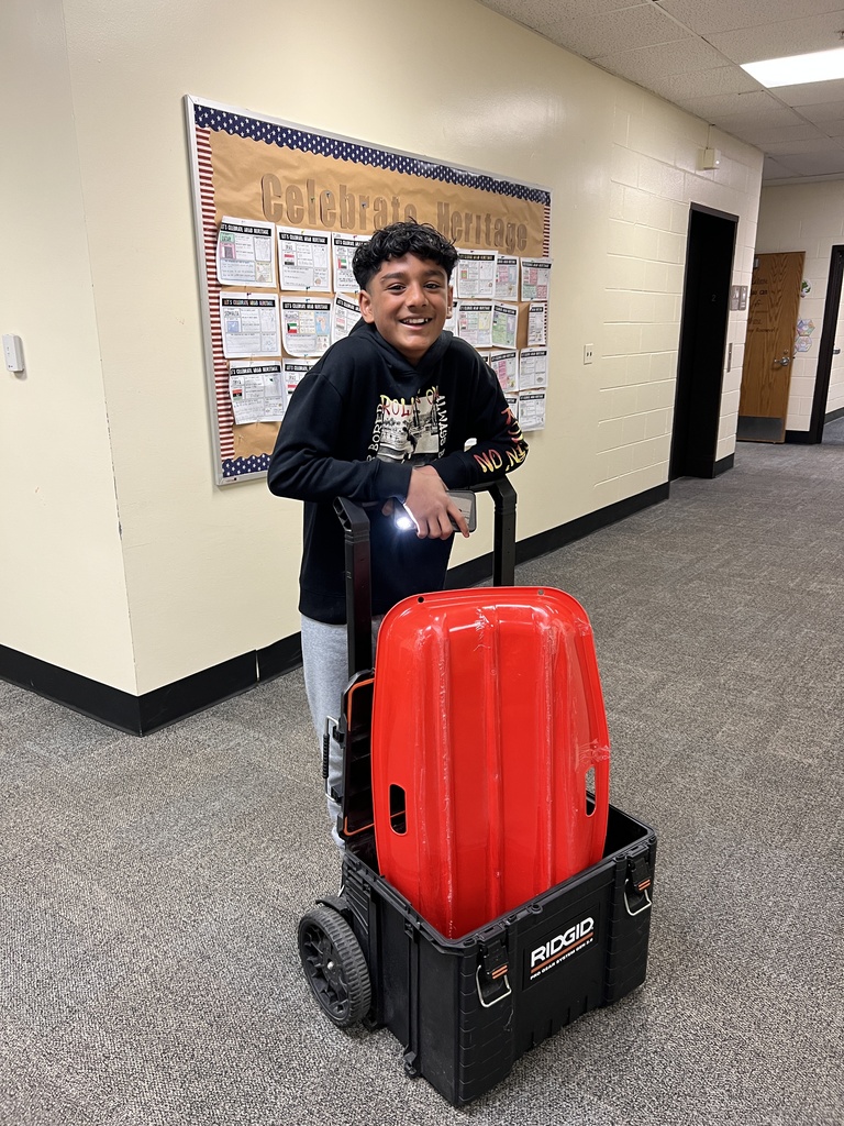 a student with a tool box and sled as a backpack