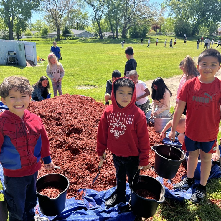 students holding buckets of mulch