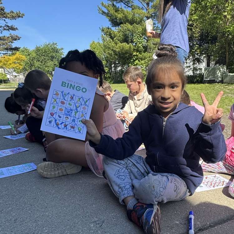student with peace sign holding winning bingo board