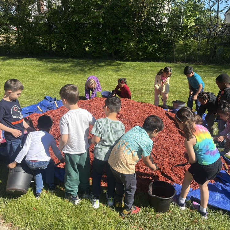 group of students digging in mulch