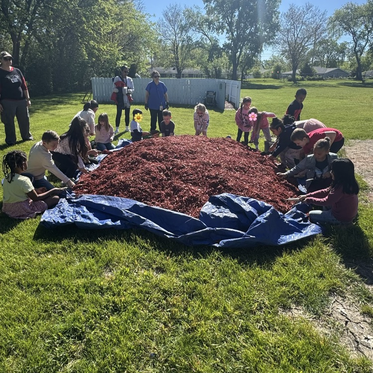group of students digging in mulch 