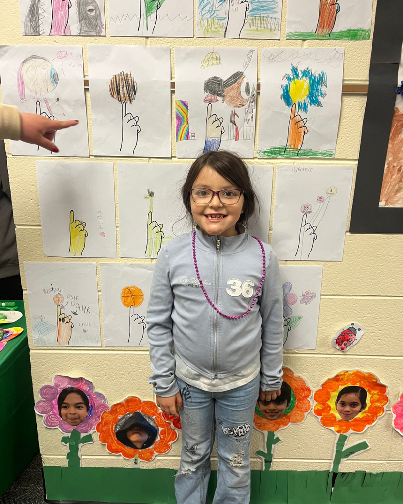 Student posig with her sign language artwork