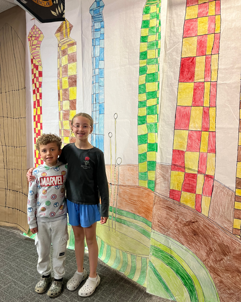 Sibling students posting in front of Harry Potter background