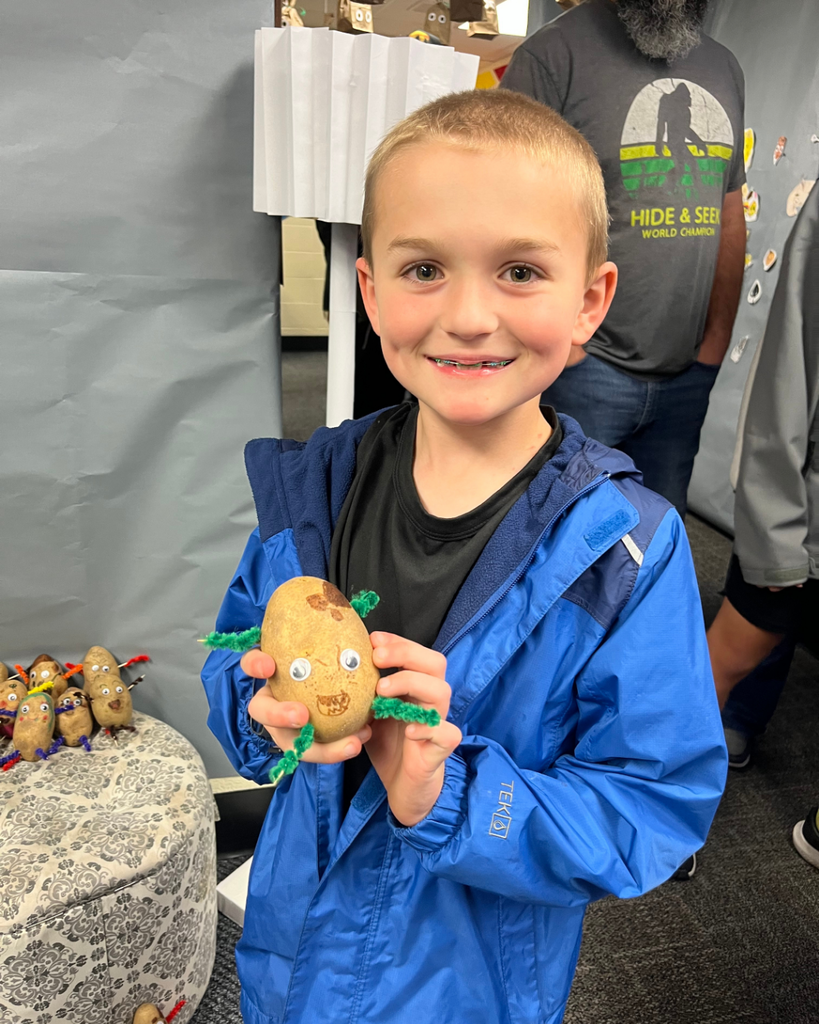 Student posing with his potato artwork