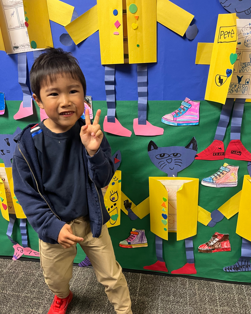 Student posing with his Pete the Cat artwork