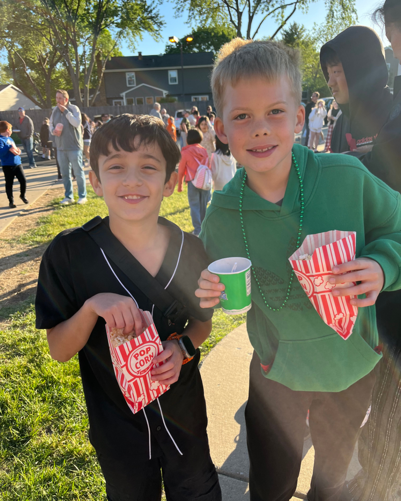 Students smiling outside together while eating popcorn