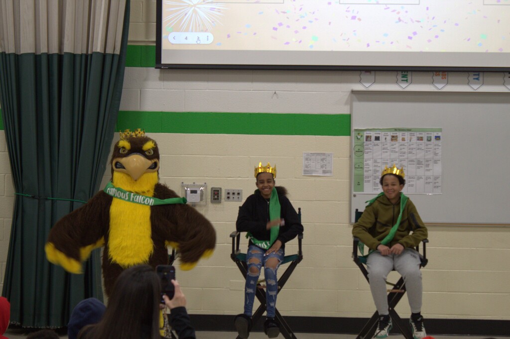 Three students wearing crowns and sashes.