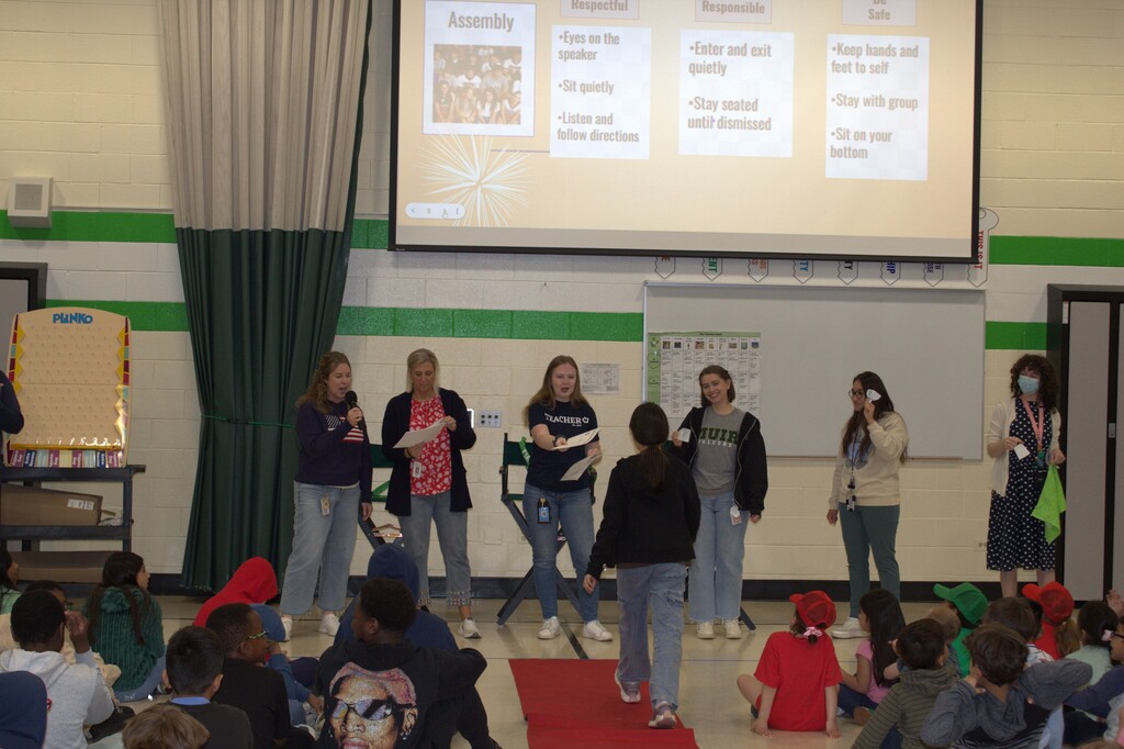 A student walking up to recieve a certificate from teachers. 
