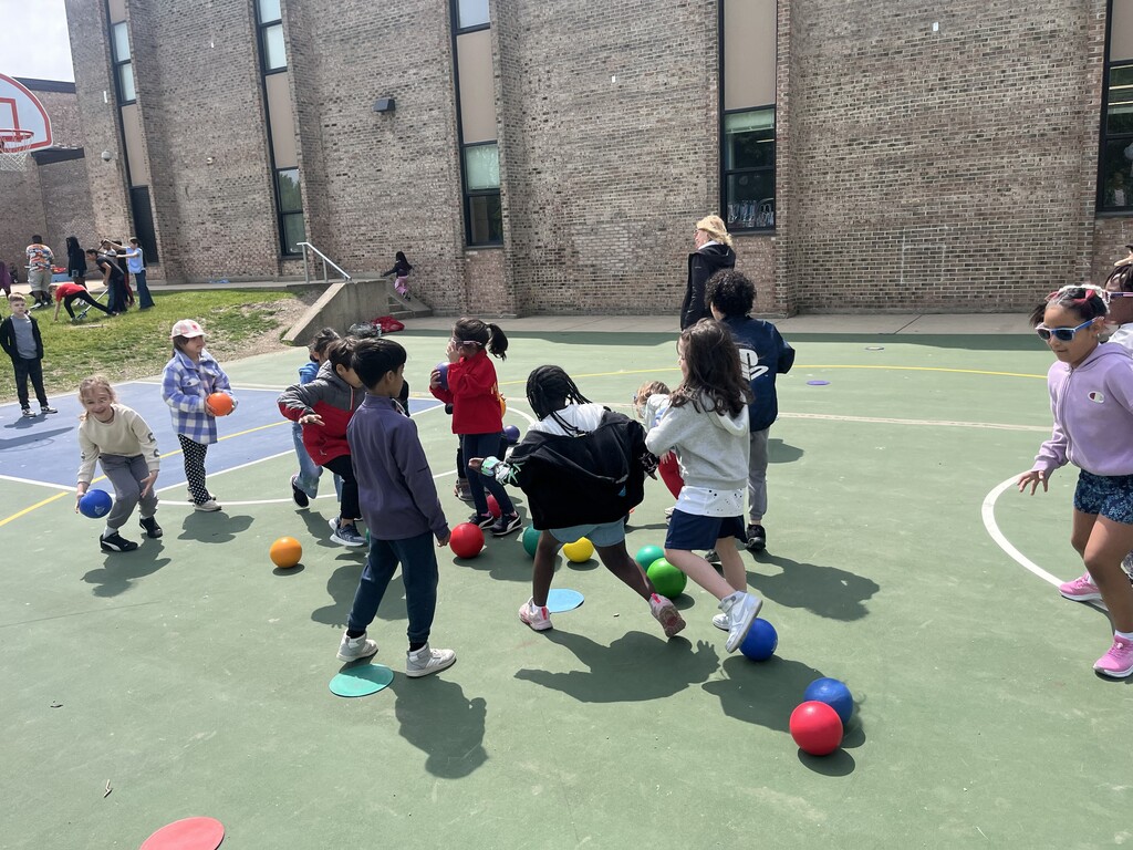 Students playing on a basketball court with squishy balls