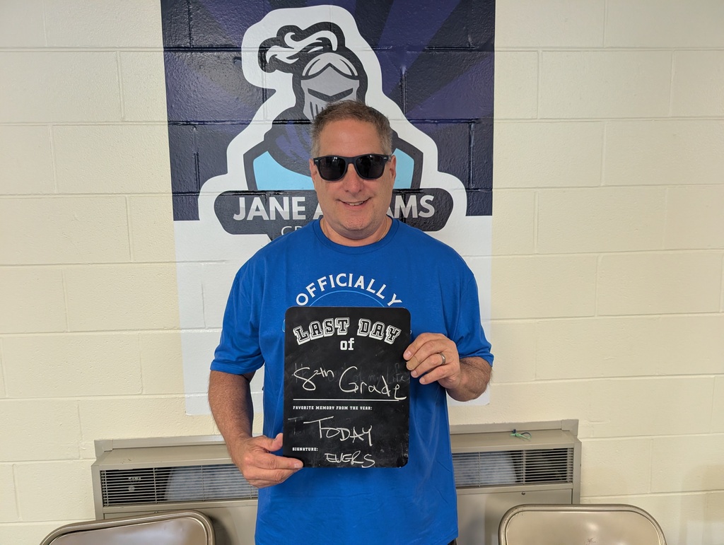 Teacher holding up a last day of school sign