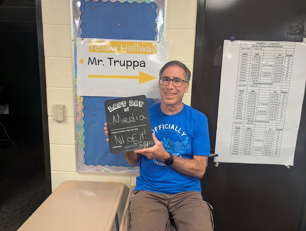 Teacher holding up a last day of school sign