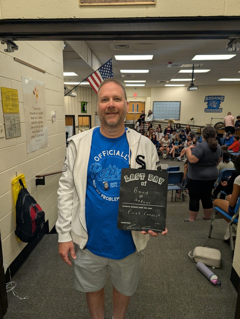 Teacher holding up a last day of school sign