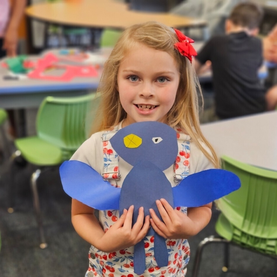 student holding the monster they made