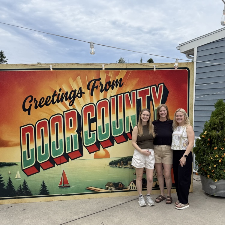 standing in front of door county sign