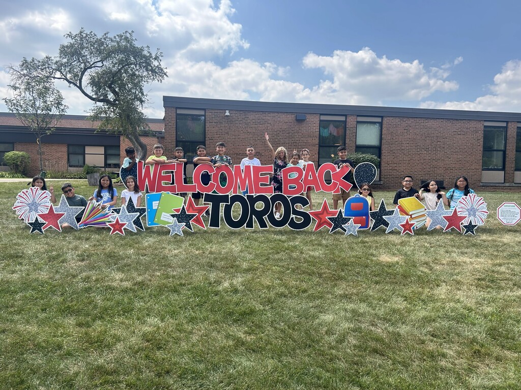 Students stand in front of welcome back sign