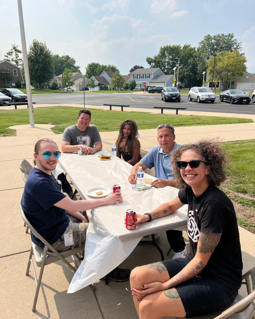 Blackwell staff and their families visiting together while enjoying BBQ foods