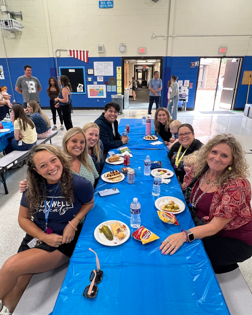 Blackwell staff and their families visiting together while enjoying BBQ foods