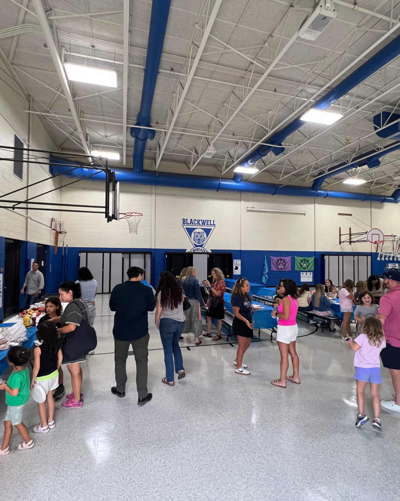 Blackwell staff and their families visiting together while enjoying BBQ foods