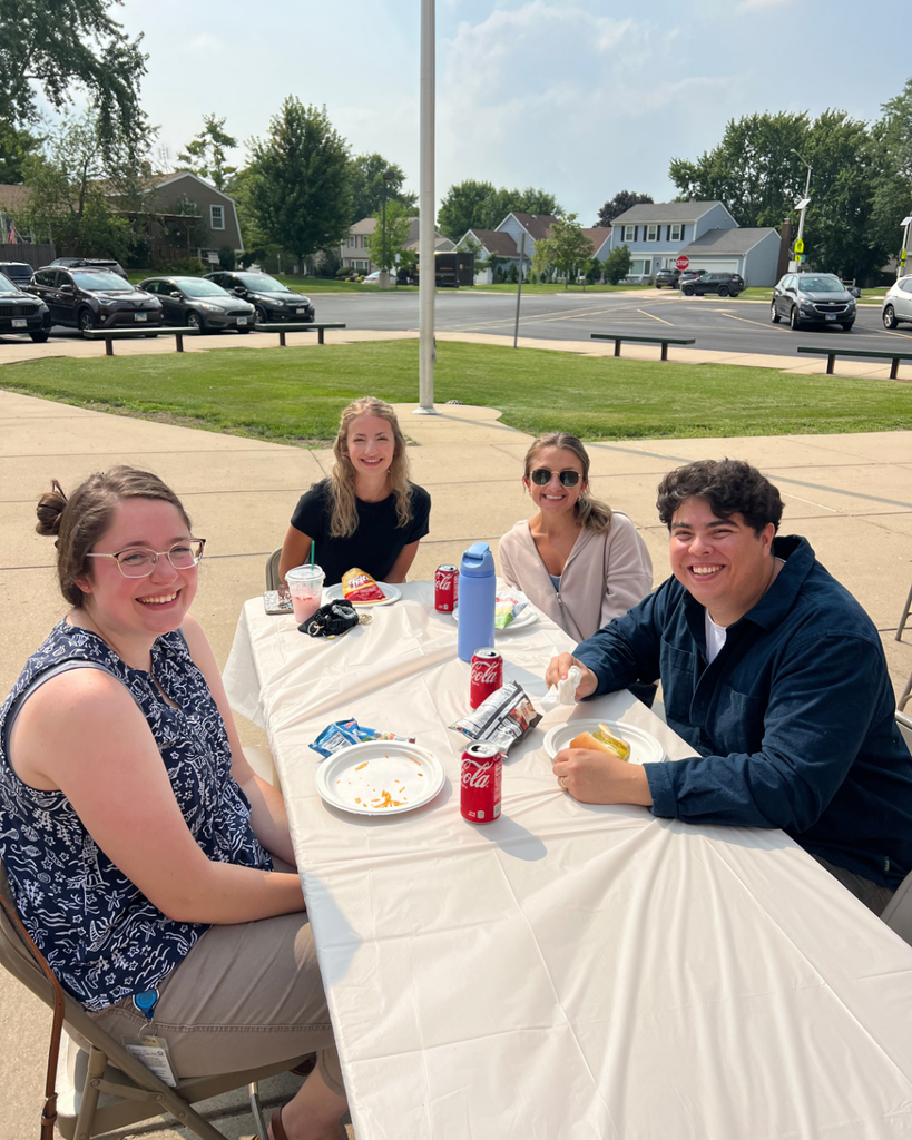 Blackwell staff and their families visiting together while enjoying BBQ foods