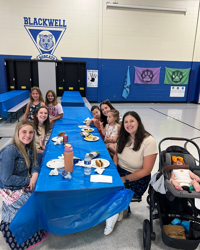 Blackwell staff and their families visiting together while enjoying BBQ foods