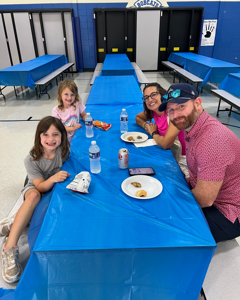 Blackwell staff and their families visiting together while enjoying BBQ foods
