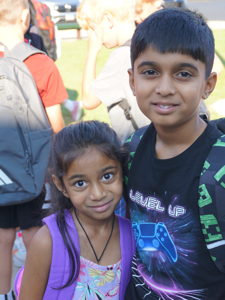Siblings smiling on first day of school