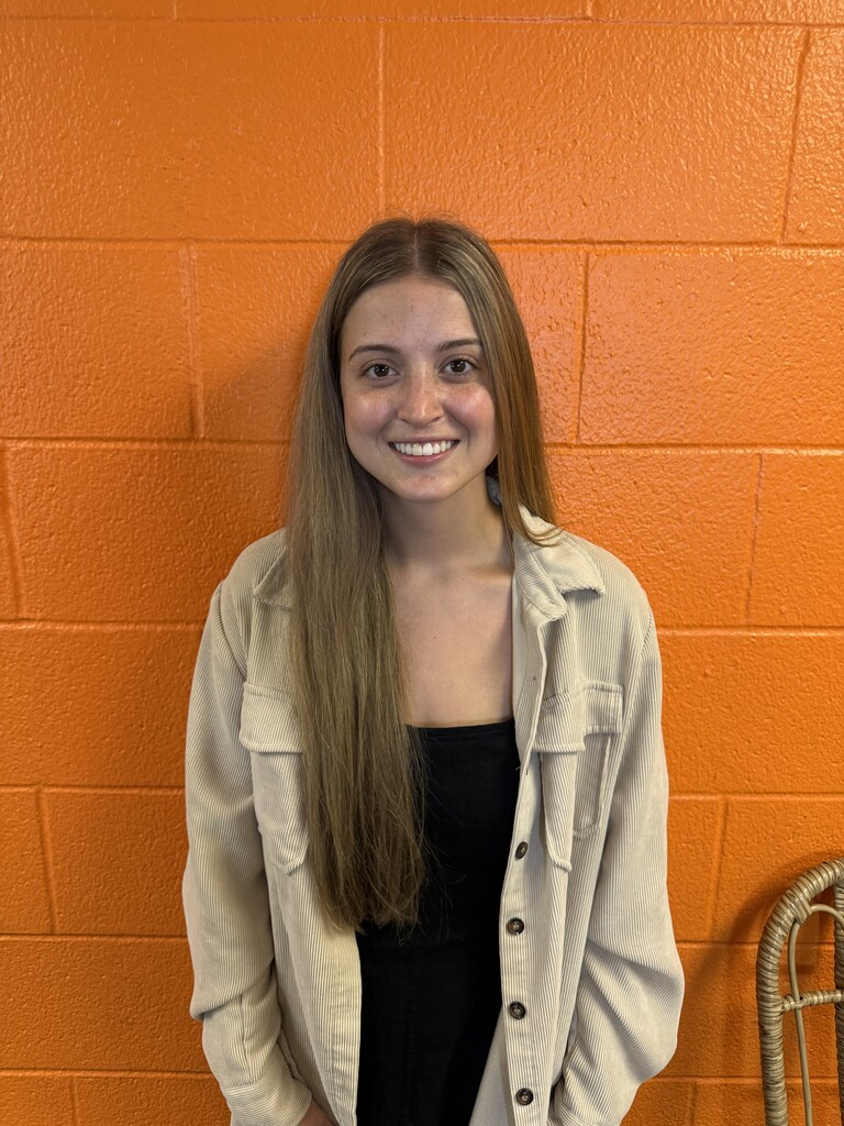 Women standing by orange wall