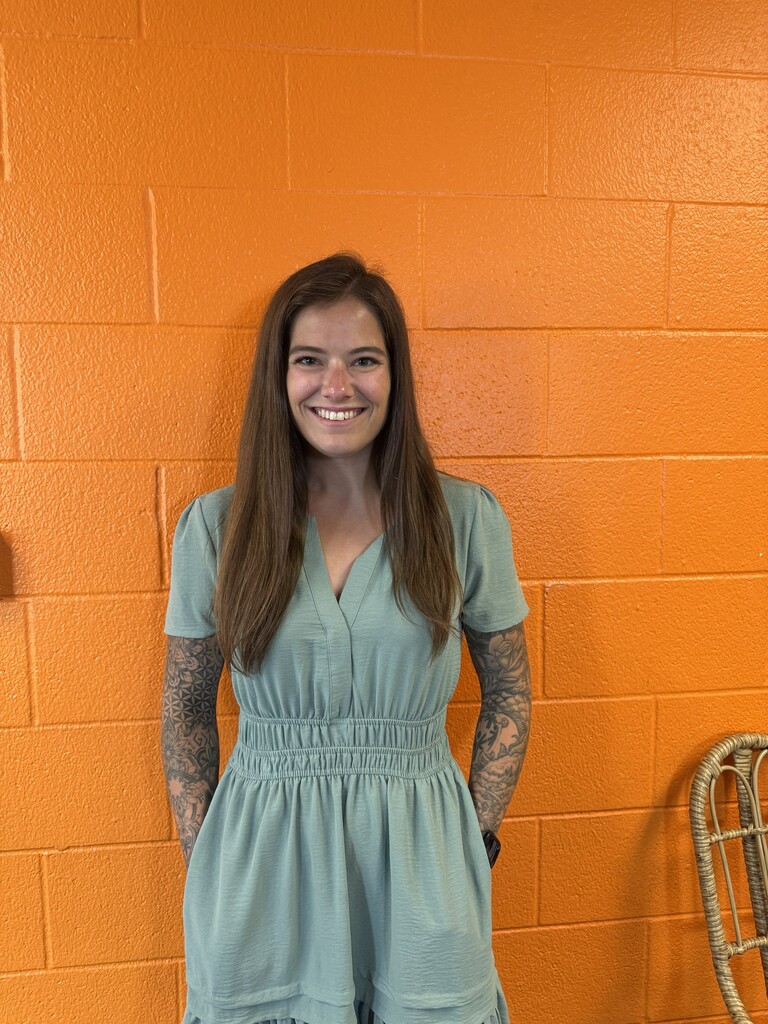 Woman smiling by orange wall
