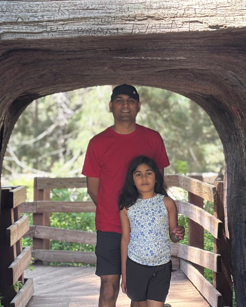 Father and daughter under sequoia tunnel